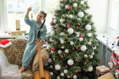 Neşeli Noel ve mutlu tatiller tatlı küçük çocuk kız kapalı Noel ağacı süsleme