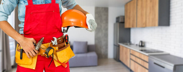 Professional builder with tool belt, space for text.