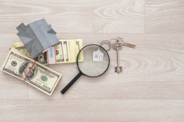 Dolar, büyüteç yanında oyuncak ev, emlak satışı, kiralık konut..