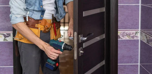 handyman fixing or repairing apartment wooden door lock. home furniture adjusting. door repair concept