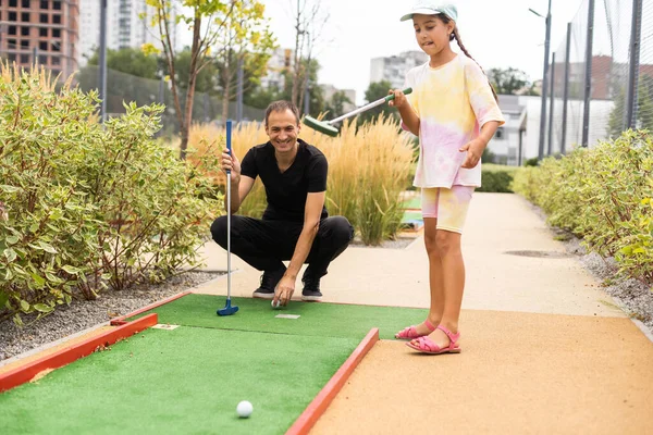 Family Playing Miniature Golf Outdoors — Zdjęcie stockowe