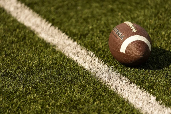 American football on football field background.