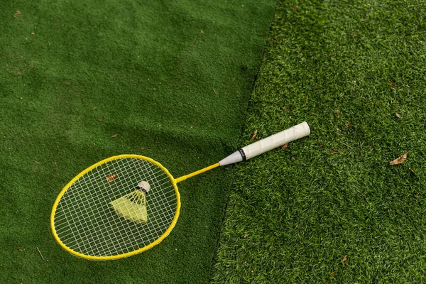 緑の芝生に羽根ではバドミントンのラケット — ストック写真