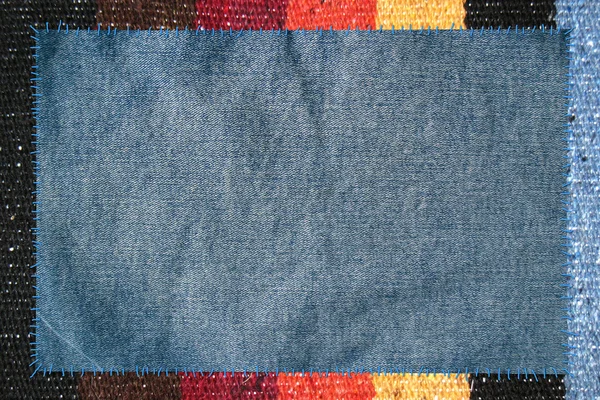 Doek verbonden door draden aan jeans — Stockfoto