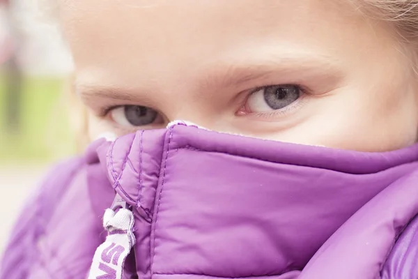 Agradável congelando menina escondido atrás do colete roxo — Fotografia de Stock