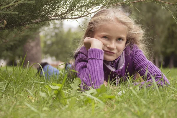 Sad girl lying on the grass — Stock Photo, Image