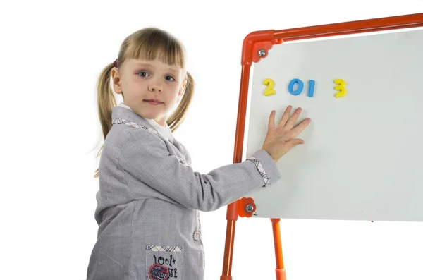 Niña enseñando cerca de la junta en el estudio —  Fotos de Stock