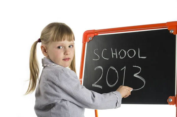 Klein meisje onderwijs in de buurt van bestuur in studio — Stockfoto