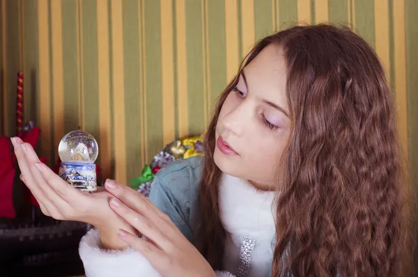 Teen girl looking at snow globe — Stock Photo, Image