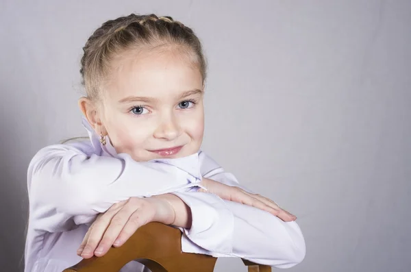 Porträtt av en skolflicka på stolen i studio — Stockfoto