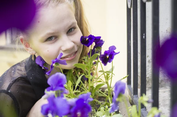 Junges Mädchen schnüffelt wunderschöne Blumen — Stockfoto