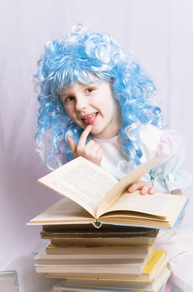 Маленькая девочка с голубыми волосами пишет книгу — стоковое фото