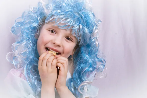 Liten flicka med blå hår äta cookie — Stockfoto