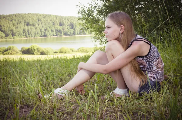 Söta tonårsflicka som sitter på gräset — Stockfoto