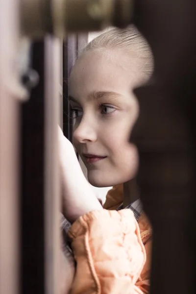 Bambina guardando gettare finestra della porta — Foto Stock