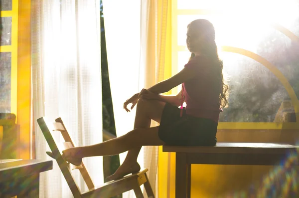 Young girl sitting on the table — Stock Photo, Image