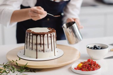 Pastasını yaparken yanında duran güzel kadın pasta şefi. Pastaya krema sürüyorum..