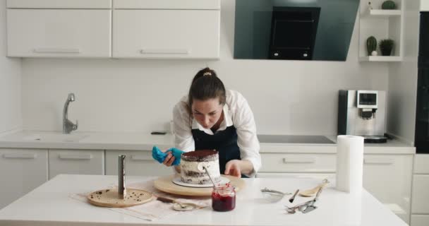 Mulher a fazer bolo de chocolate na cozinha, close-up. Processo de fabricação de bolos, foco seletivo — Vídeo de Stock