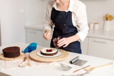 Kadın mutfakta çikolatalı pasta yapıyor, yakın plan. Böğürtlen. Kadın elleri, yaklaşın. Pasta yapma süreci, Seçici odak