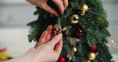 Noel ağacını süsleyen ve Noel arifesini kutlamaya hazır bir kadının eli. Mutluluk, Noel, ruh hali, yardım.