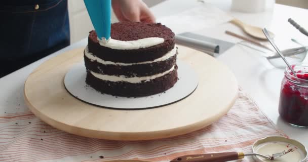 Cukrárna v práci. Smetanový dort zdobení a plnění. Cukrárna naplňuje dort náplní z sáčku. — Stock video