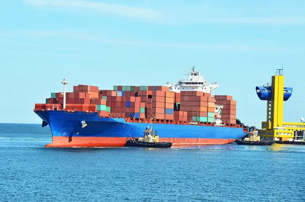 Tugboat assisting container cargo ship — Stock Photo, Image