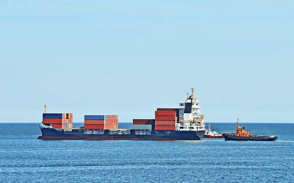 Embarcação de rebocador que ajuda navio de carga — Fotografia de Stock