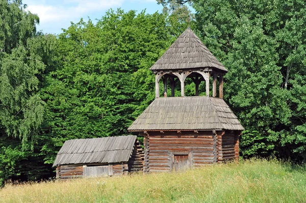 Staré dřevěné stodoly a kostel — Stock fotografie