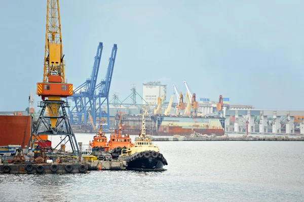 Tugboat and freight train under port crane — Stock Photo, Image