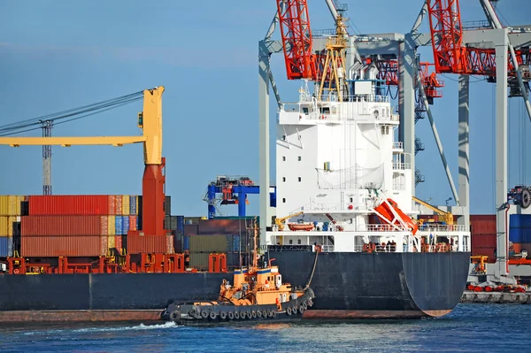 Tugboat assisting container cargo ship — Stock Photo, Image