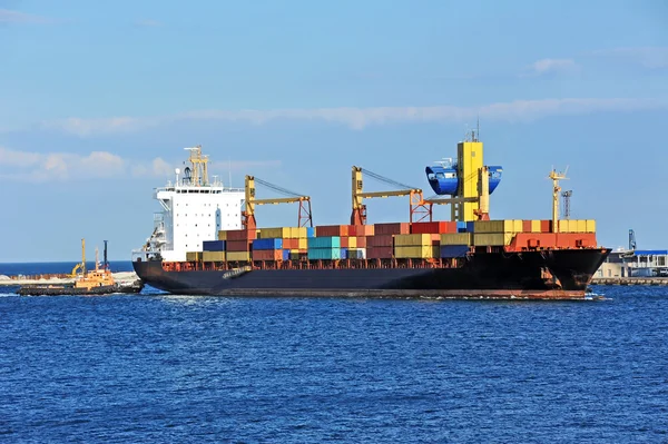 Tugboat assisting container cargo ship — Stock Photo, Image