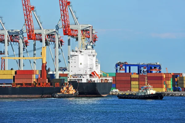 Tugboat assisting container cargo ship — Stock Photo, Image