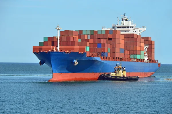 Tugboat assisting container cargo ship — Stock Photo, Image