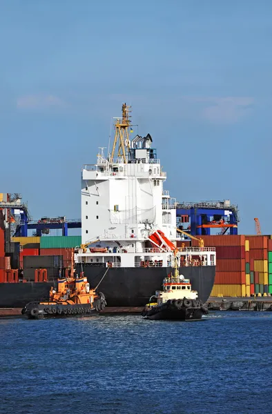 Tugboat assisting container cargo ship — Stock Photo, Image