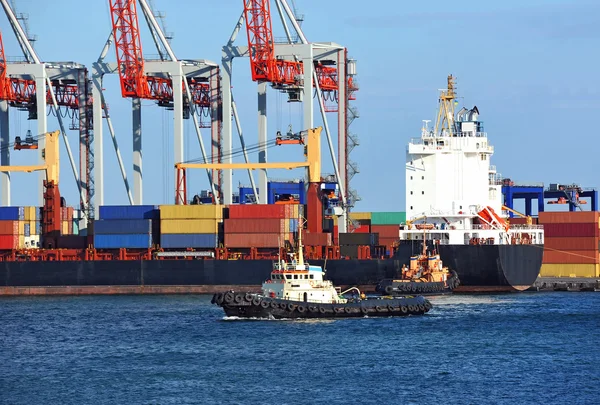 Tugboat assisting container cargo ship — Stock Photo, Image