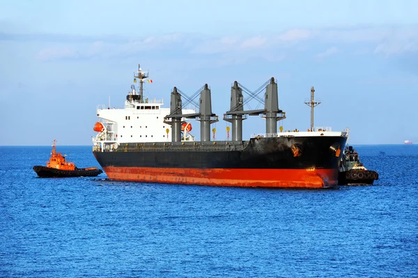 Tugboat assisting bulk cargo ship — Stock Photo, Image