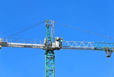 Mavi gökyüzüne karşı yüksek inşaat kulesi vinci