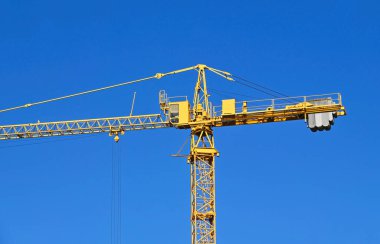 Mavi gökyüzüne karşı yüksek inşaat kulesi vinci