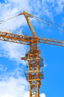 Mavi gökyüzüne karşı yüksek inşaat kulesi vinci