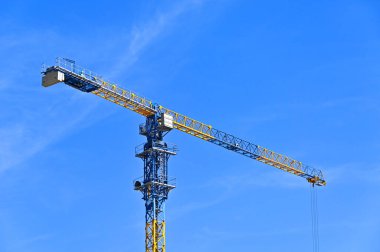 Mavi gökyüzüne karşı yüksek inşaat kulesi vinci