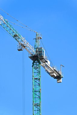 Mavi gökyüzüne karşı yüksek inşaat kulesi vinci