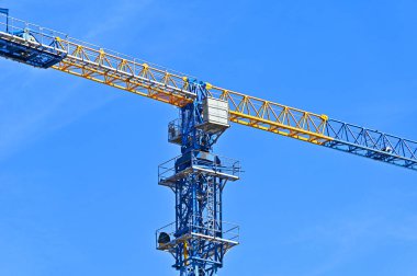 Mavi gökyüzüne karşı yüksek inşaat kulesi vinci