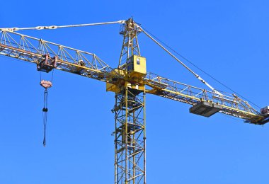 Mavi gökyüzüne karşı yüksek inşaat kulesi vinci