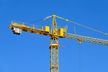 Mavi gökyüzüne karşı yüksek inşaat kulesi vinci