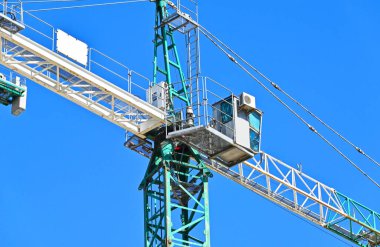 Mavi gökyüzüne karşı yüksek inşaat kulesi vinci