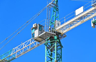 Mavi gökyüzüne karşı yüksek inşaat kulesi vinci