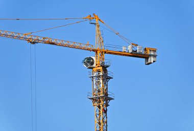 Mavi gökyüzüne karşı yüksek inşaat kulesi vinci