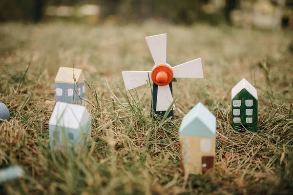 Street with toy wooden houses and windmills on the grass. Small toy houses, mill.