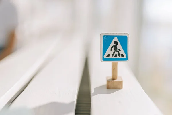 Pedestrian crossing sign. Toy wooden sign close up on a light background. Conceptual photo of traffic rules