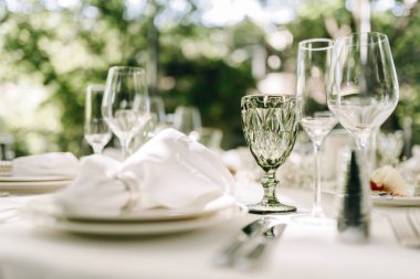 Beautiful wine glasses on a set table outdoors